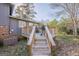 Backyard view showcasing deck with stairs, a grill, and a spacious yard with mature trees at 3006 Deshong Dr, Stone Mountain, GA 30087