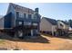 Backyard view of a home with a deck and walkout basement at 9989 Village South Dr, Douglasville, GA 30135