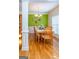 Bright dining room featuring wood floors, wainscoting and bright green accent wall at 9989 Village South Dr, Douglasville, GA 30135