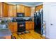 Efficient kitchen featuring wood cabinets and modern black appliances at 9989 Village South Dr, Douglasville, GA 30135