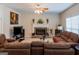 Inviting living room features a stone fireplace, ceiling fan, and comfortable, oversized brown couches at 9989 Village South Dr, Douglasville, GA 30135