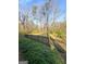 View of spacious backyard with black metal fence and green ground cover, and view of the trees at 1972 Cox Dr, Austell, GA 30168