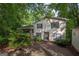 Two story home with a yard and porch nestled among mature trees at 1972 Cox Dr, Austell, GA 30168