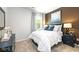 Serene bedroom with modern decor, soft white bedding, dark navy end tables, and ample natural light from the window at 201 Friendship Oak Way, Hampton, GA 30228