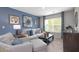 A well-lit living room with blue walls and a comfortable seating arrangement at 201 Friendship Oak Way, Hampton, GA 30228