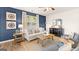 Bright living room featuring a comfortable sofa, wood coffee table, and a decorative rug at 201 Friendship Oak Way, Hampton, GA 30228