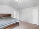 Neutral bedroom with carpet, a wooden bed frame, and neutral-toned walls at 445 Sawmill Trce, Hampton, GA 30228