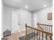 Second floor hallway featuring neutral decor, railing and multiple access points to rooms at 445 Sawmill Trce, Hampton, GA 30228