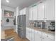 Well-equipped kitchen featuring white cabinets, stainless steel refrigerator, and granite countertops at 445 Sawmill Trce, Hampton, GA 30228