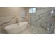Elegant bathroom featuring soaking tub, a glass-enclosed shower, and marble-look tile at 2085 Dellwood Pl, Decatur, GA 30032