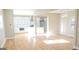 Sunlit open-concept living area with hardwood floors and view of kitchen with white cabinetry at 2085 Dellwood Pl, Decatur, GA 30032