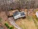 Aerial view of a home with a large driveway, surrounded by lush trees and a well-maintained lawn in a quiet neighborhood at 3747 Junior Ln, Douglasville, GA 30135