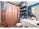 Compact bathroom with blue walls, showcasing wall shelves and a patterned shower curtain at 3747 Junior Ln, Douglasville, GA 30135