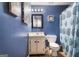 Cozy bathroom with blue walls featuring patterned shower curtain and classic vanity at 3747 Junior Ln, Douglasville, GA 30135