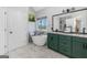 Relaxing bathroom with freestanding tub, marble floors, green vanity with double sinks, and natural light at 305 Worthing Lane, Mcdonough, GA 30253