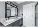 Renovated bathroom with a double sink vanity, modern lighting, and a framed mirror at 305 Worthing Lane, Mcdonough, GA 30253