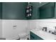 Stylish half-bathroom features modern vanity, a dark green wall, and a toilet at 305 Worthing Ln, Mcdonough, GA 30253