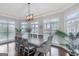 Sun-filled dining room with large windows, an elegant chandelier, and seating for eight at 305 Worthing Lane, Mcdonough, GA 30253