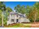 Charming two-story home boasts a blue front door, lush landscaping, and mature trees at 305 Worthing Ln, Mcdonough, GA 30253