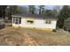 Charming single-story home with white siding, black roof, and bright yellow accents at 3100 Bay St, Scottdale, GA 30079