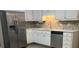 Bright kitchen area with stainless steel appliances, white cabinets, and mosaic backsplash at 328 Cattlemans Cir, Mcdonough, GA 30252