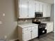 Modern kitchen featuring white cabinets, stainless steel appliances, and tiled backsplash at 328 Cattlemans Cir, Mcdonough, GA 30252