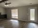 Living room with a ceiling fan, a window with blinds, and a door leading outside at 328 Cattlemans Cir, Mcdonough, GA 30252