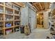 Unfinished basement with exposed ductwork and wooden shelving full of supplies at 2510 Shoreline Pkwy, Villa Rica, GA 30180