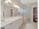 A bright bathroom featuring double sinks, a large mirror, storage shelving, and a glass shower at 2510 Shoreline Pkwy, Villa Rica, GA 30180