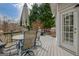 Outdoor deck furnished with a dining set, umbrella, grill, and lush trees in the background at 2510 Shoreline Pkwy, Villa Rica, GA 30180
