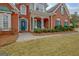 Inviting brick home with a charming front porch, blue door, and manicured landscaping for curb appeal at 2510 Shoreline Pkwy, Villa Rica, GA 30180