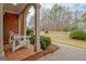 Inviting front porch with brick flooring, column supports, and seating, surrounded by lush greenery at 2510 Shoreline Pkwy, Villa Rica, GA 30180