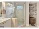 A bright bathroom featuring a shower with glass door, neutral tile, and built-in shelving for storage at 2510 Shoreline Pkwy, Villa Rica, GA 30180