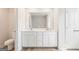 Bathroom featuring double sinks, white cabinets, large mirror, and a toilet, all complemented by wood-style flooring at 982 Sutherland Ln # 30, Lawrenceville, GA 30043