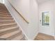 A carpeted staircase with wood railing leads to the upper level, showcasing the home's design and entryway at 982 Sutherland Ln # 30, Lawrenceville, GA 30043