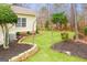 Landscaped backyard featuring an arched trellis, stone retaining walls, and lush green lawn at 1067 Pinehurst Dr, Peachtree City, GA 30269