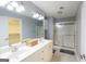 Well-lit bathroom featuring double sinks, a large mirror, and a shower with a glass door at 1067 Pinehurst Dr, Peachtree City, GA 30269