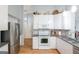 Stylish kitchen features stainless steel appliances, subway tile backsplash, and sleek white cabinets at 1067 Pinehurst Dr, Peachtree City, GA 30269