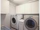Laundry room with white cabinetry and modern appliances at 1067 Pinehurst Dr, Peachtree City, GA 30269