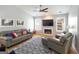 Comfortable living room with hardwood floors, a ceiling fan, a modern fireplace, and a gray leather sofa at 1067 Pinehurst Dr, Peachtree City, GA 30269