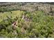 An aerial view of a beautiful estate surrounded by lush greenery and a vast open field at 1561 Aiken Chafin Ln, Mcdonough, GA 30252