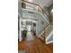 Bright foyer with hardwood floors, staircase, white banister and Charleston sign at 1561 Aiken Chafin Ln, Mcdonough, GA 30252