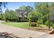 Charming home featuring a lush lawn and beautiful landscaping, complemented by a circular driveway at 1561 Aiken Chafin Ln, Mcdonough, GA 30252