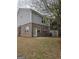 View of the townhome's backyard featuring a small patio and a tree with white blossoms at 1463 River Stone Trce, Conyers, GA 30012