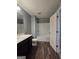 Bathroom featuring a vanity with dark wood cabinetry, a tub and shower, and wood-look flooring at 1463 River Stone Trce, Conyers, GA 30012