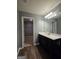 Bathroom featuring a vanity with a large mirror, an open door, and wood-look flooring at 1463 River Stone Trce, Conyers, GA 30012