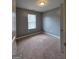 Bedroom with neutral walls and carpet, featuring a window with blinds for natural light at 1463 River Stone Trce, Conyers, GA 30012