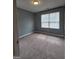Bedroom with neutral walls and carpet, featuring a window with blinds for natural light at 1463 River Stone Trce, Conyers, GA 30012