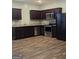 Well-lit kitchen featuring dark cabinetry, granite countertops, and stainless steel appliances at 1463 River Stone Trce, Conyers, GA 30012