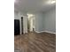 Open living space with wood-look flooring and light grey walls, featuring a closet and a door to the bathroom at 1463 River Stone Trce, Conyers, GA 30012